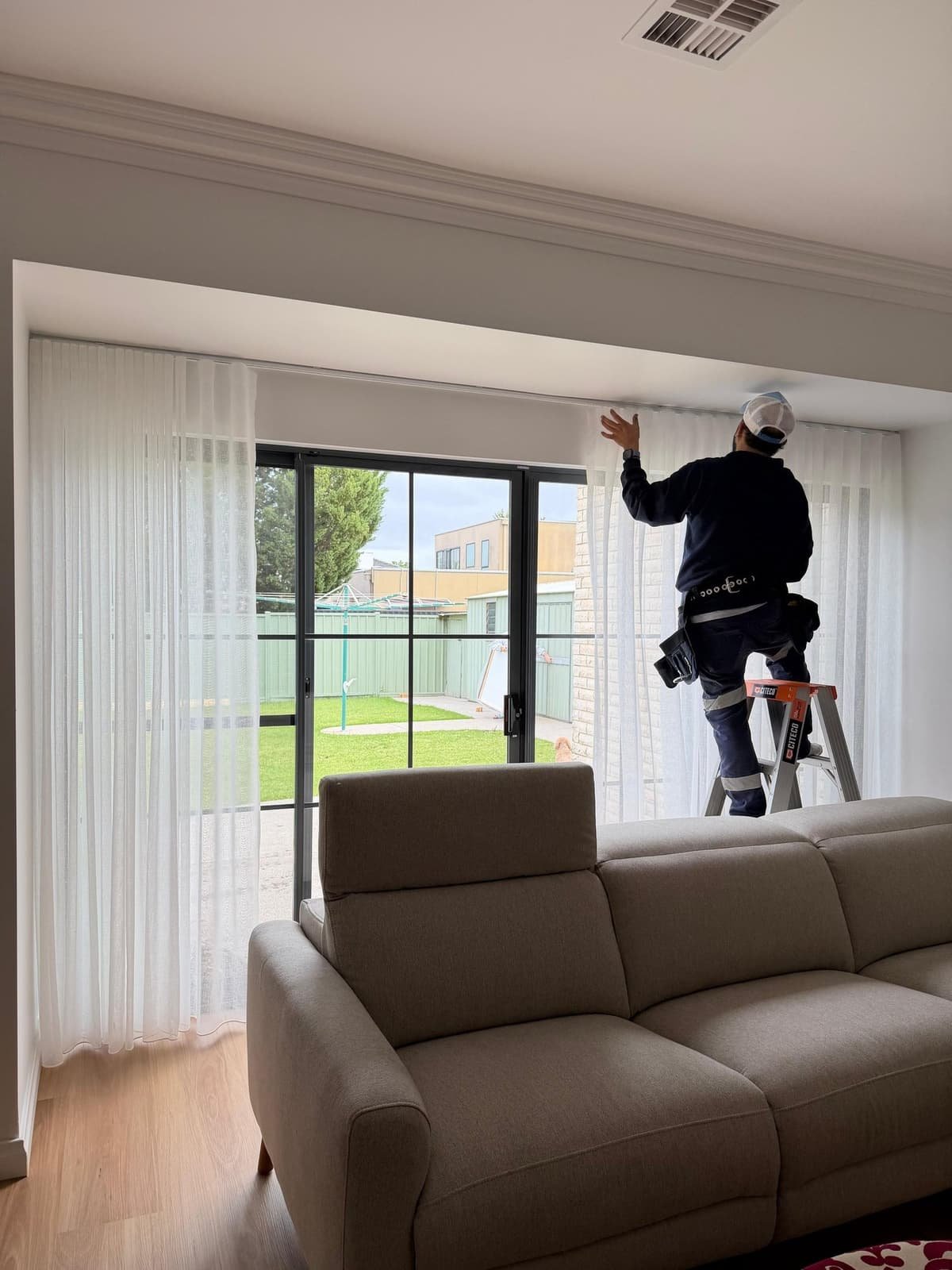 Shades & More installing curtains