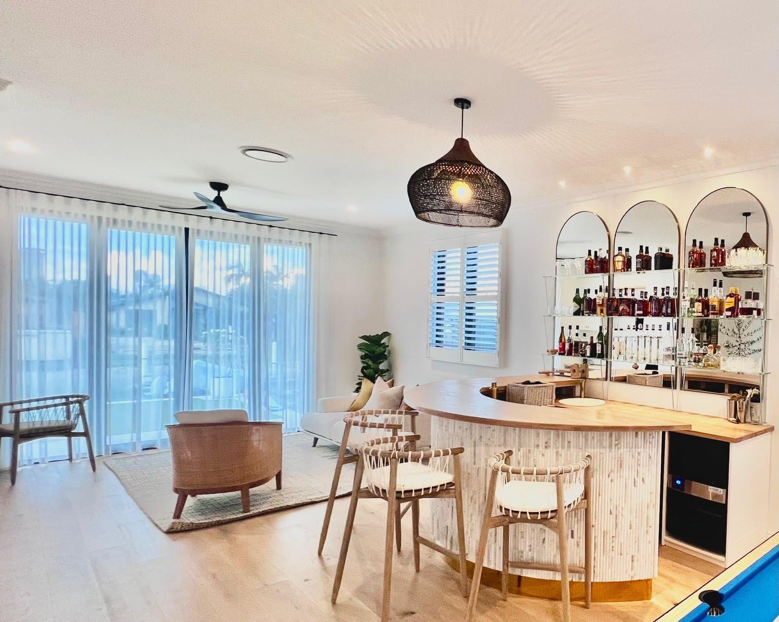 Open-plan living room dressed with custom window furnishings